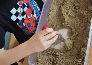 dzieci szukają szczątek diznoazura w piasku