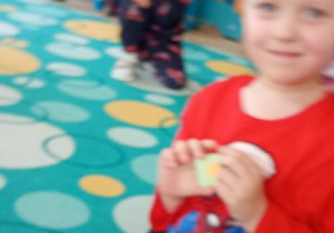 Artur układa elemnty marcowej pogody na garnku.