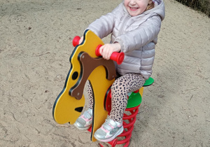 Dziewczynka bawi się na koniku