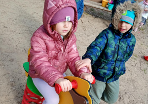 Dzieci bawią się na bujanym koniku