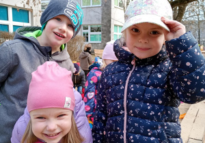 Przedszkolaki pozują do zdjęcia podczas zabawy w piaskownicy