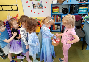 Dziewczynka częstuje cukierkami z okazji Balu Karnawałowego