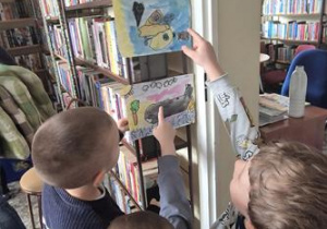 Dzieci szukają swoich prac na wystawie