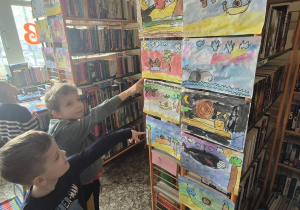 Dzieci szukają swoich prac na wystawie