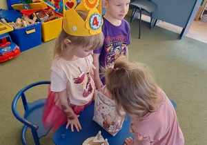 Dziewczynka częstuje się urodzinowym cukierkiem