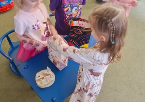 Dziewczynka częstuje się urodzinowym cukierkiem