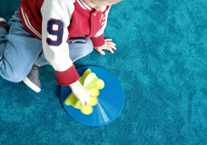 Chłopiec odlicza żabki