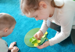 Dziewczynka odlicza trzy sylwety żabek