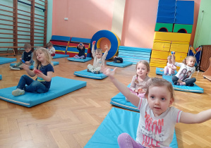 Dzieci przekładają woreczki z ręki do ręki nad głowami