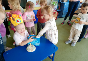 Dziewczynka częstuje się urodzinowym cukierkiem