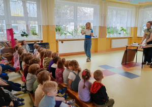 Autorka pokazuje dzieciom ilustracje w książce