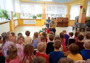 Prowadząca czyta fragment książki dzieciom