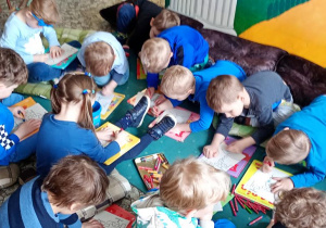 Dzieci kolorują kolorowanki.