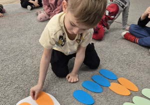 Wojtek układa pisanki według instrukcji nauczyciela