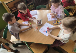 Dzieci stawiają stempelki pokazujące różne emocje