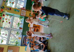 Maluszki nawlekają marchewki na rolki, naśladując jedzące warzywa słonie