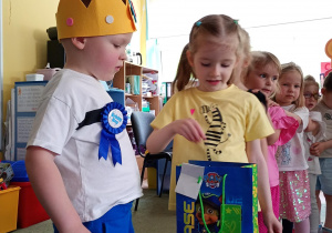 Dziewczynka częstuje się urodzinowym cukierkiem od kolegi