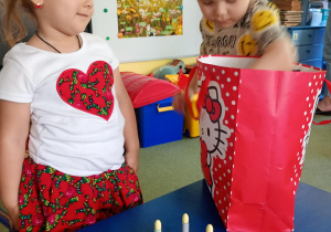 Chłopiec częstuje się urodzinowymi słodkościami od koleżanki