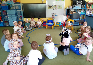 Puchatki przyglądają się papierowej sylwecie białej krowy