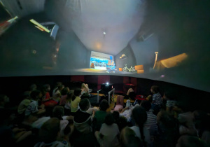 Dzieci oglądają film edukacyjny w mobilnym planetarium