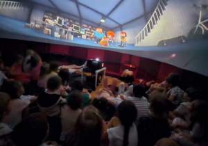 Dzieci oglądają film edukacyjny w mobilnym planetarium