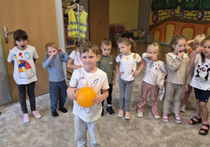 Kuba stoi z piłką pośrodku koła, zabawa "Introduce yourself"