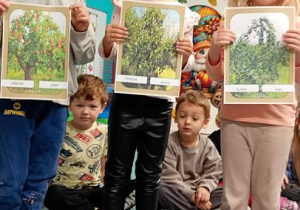 Staś Bianka i Małgosia prezentują na obrazku jesiennne drzewa.