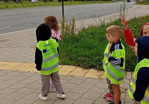 Dzieci obserwują zmianę światła na sygnalizatorze świetlnym.