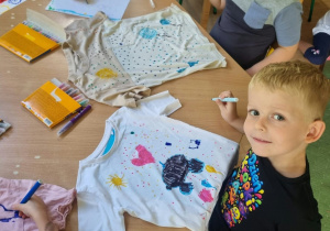 Igor, Milan I Oliwia malują kropki na koszulkach