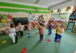 Dzieci stoją na kolorowych kołach parami