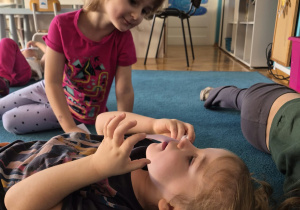 Dziewczynki sprawdzają czy trudno zdmuchnąć papierek