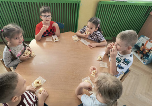 dzieci jedzą upieczone ciasteczka