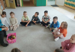 nauczyciel opowiada dzieciom o owocach